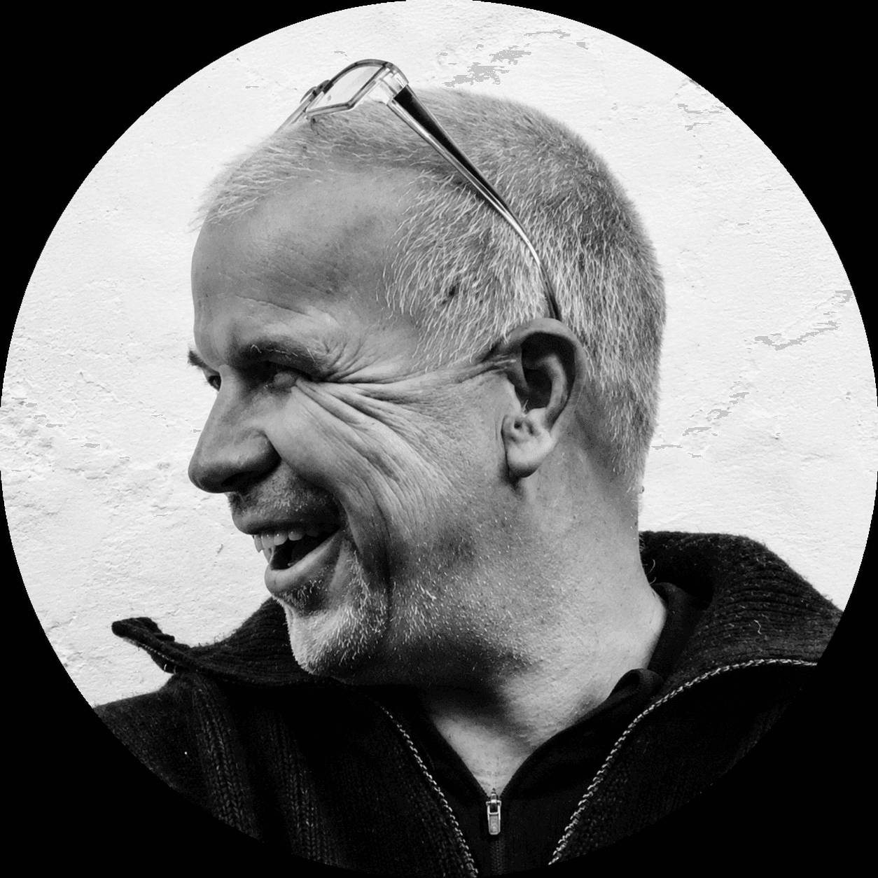 Dirk Ottenheym, black-and-white close portrait in profile, laughing, glasses pushed up onto his head.